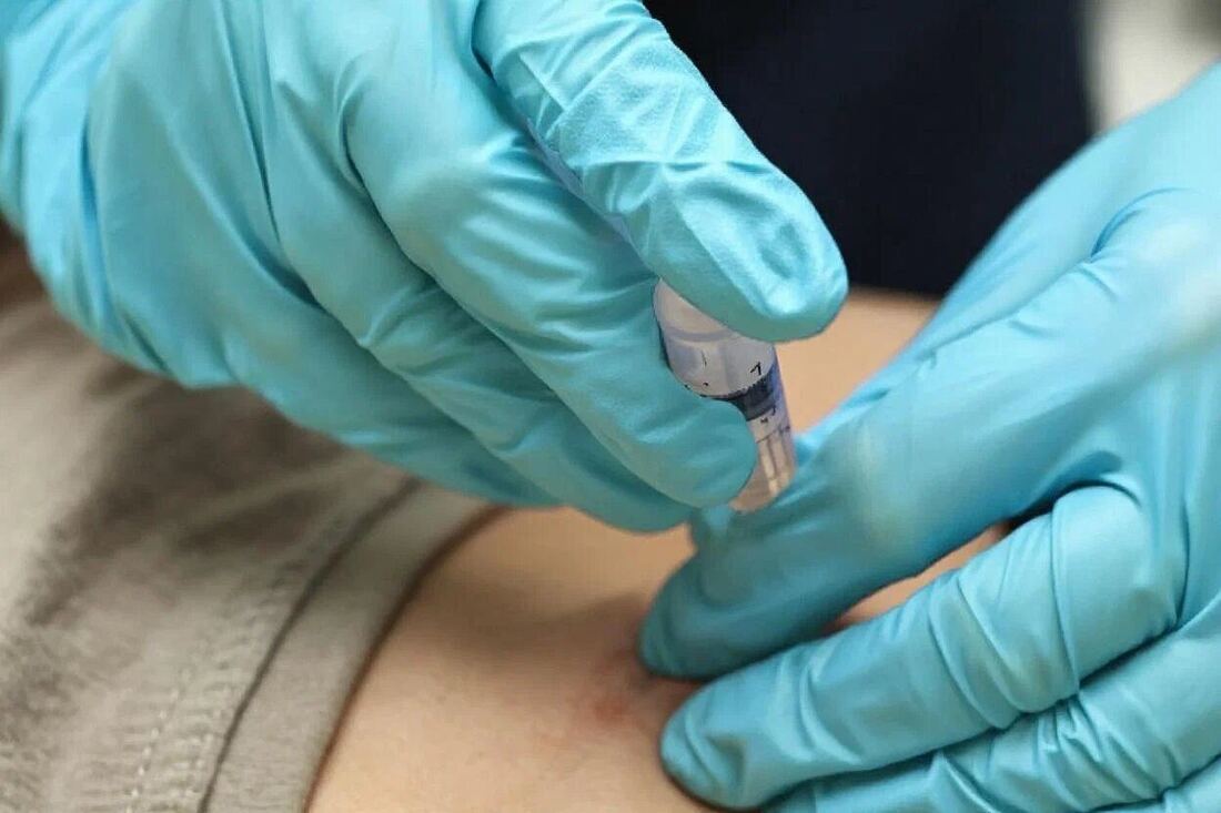 Инъекционная процедура, руки врача в перчатках крупным планом